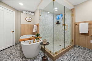 Full bath with a freestanding tub, a stall shower, a wainscoted wall, light floors, and recessed lighting