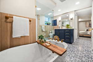 Ensuite bathroom featuring a freestanding bath, vanity, a stall shower, and recessed lighting