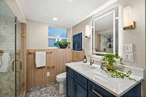 Bathroom featuring vanity, a shower stall, and a textured wall