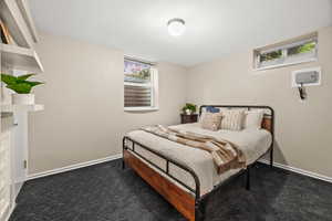 Bedroom featuring dark carpet and baseboards