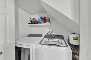 Laundry area featuring vaulted ceiling and washing machine and clothes dryer
