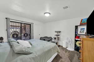 Bedroom with dark colored carpet and baseboards