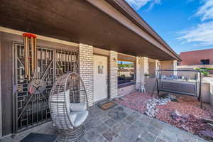 Doorway to property with covered porch and brick siding