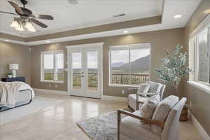 Bedroom with french doors, ornamental molding, a tray ceiling, a mountain view, and recessed lighting