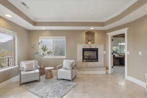 Living area featuring recessed lighting, a premium fireplace, a raised ceiling, ornamental molding, and a mountain view