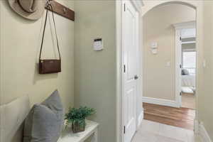 Hallway with arched walkways and light tile patterned floors