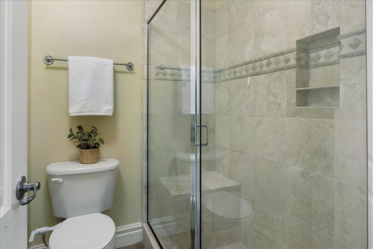 Bathroom featuring toilet and a shower stall