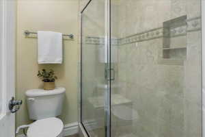 Bathroom featuring toilet and a shower stall