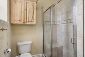 Full bath with toilet and a shower stall