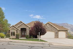 View of front of house featuring stone siding, french doors, an attached garage, driveway, and a shingled roof