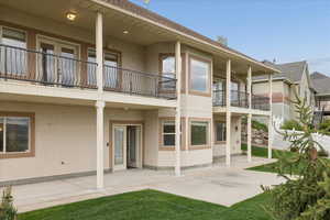 Rear view of property featuring stucco siding, a patio area, and a balcony