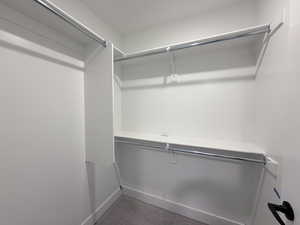 Walk in closet with dark colored carpet