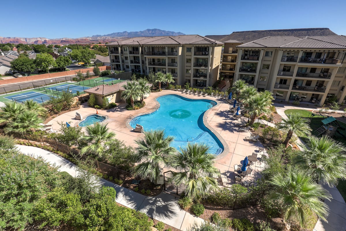 Community pool with a patio and a tennis court