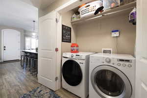 Laundry area with light wood finished floors and washing machine and clothes dryer