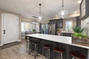 Kitchen with a breakfast bar, a peninsula, stainless steel appliances, and dark wood finish cabinets