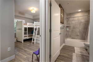 Bathroom with dark wood finished floors and shower / bath combo