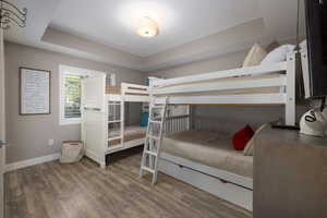 Bedroom with a raised ceiling and dark wood finished floors