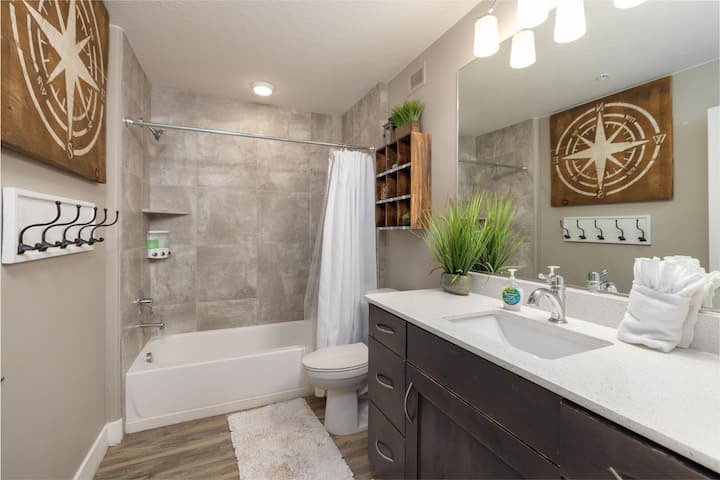 Bathroom featuring vanity, shower / bathtub combination with curtain, and wood finished floors