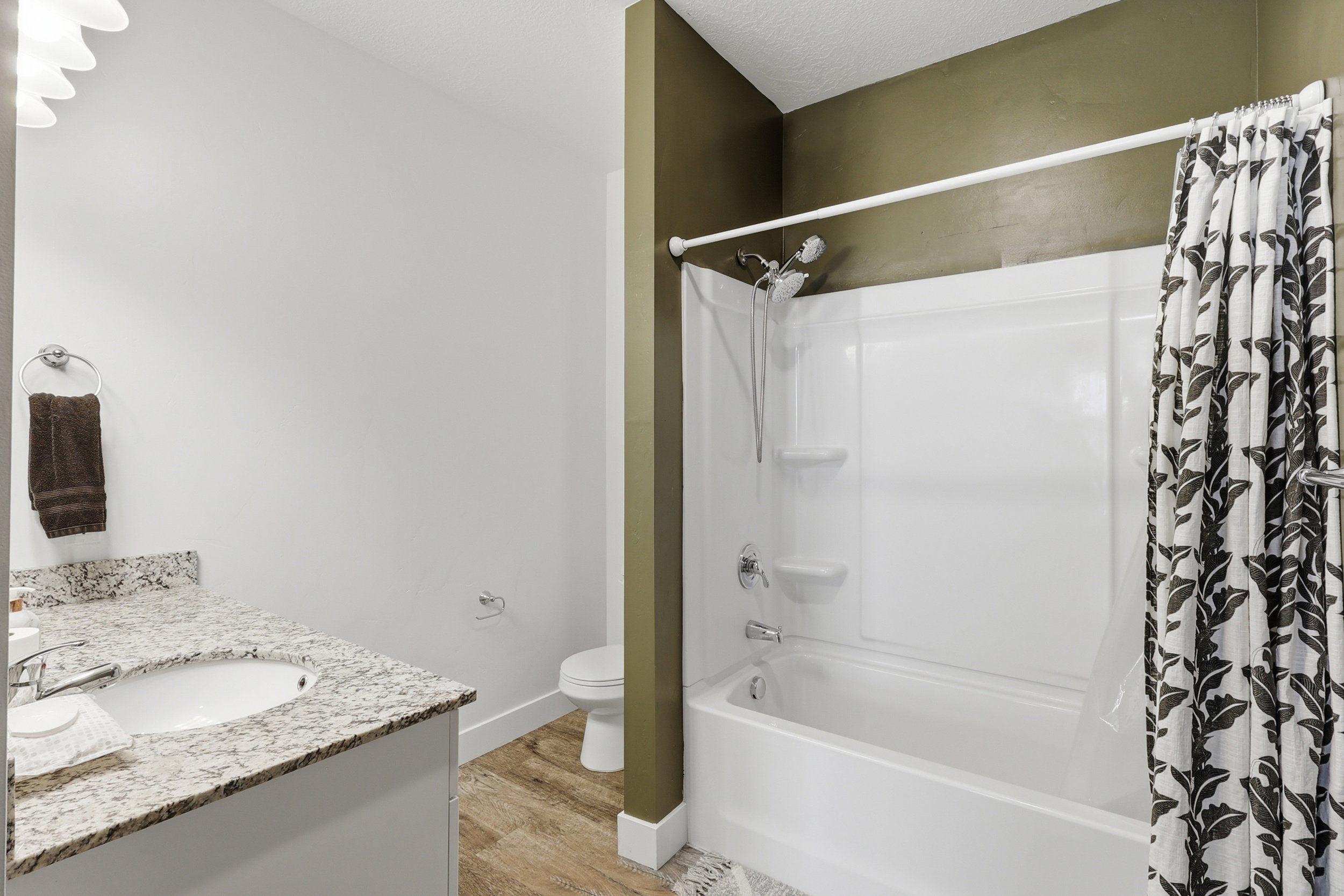 Full bath featuring vanity, shower / bath combo with shower curtain, and light wood-type flooring