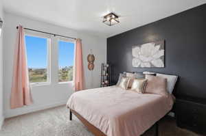 Bedroom with carpet flooring, an accent wall, and a textured ceiling