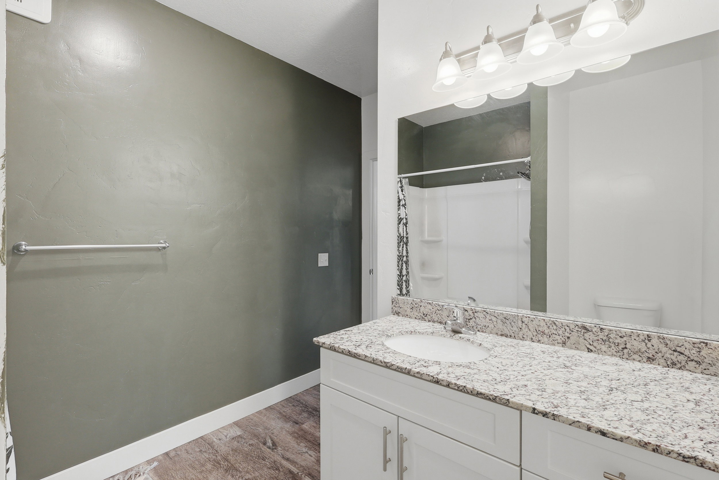 Bathroom featuring vanity, light wood-style flooring, and curtained shower