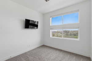 Spare room with baseboards and light carpet