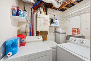 Laundry room featuring independent washer and dryer and water heater