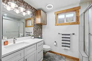 Full bathroom with vanity and a shower stall