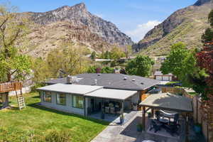 Rear view of property featuring a mountain view and a patio area