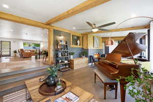 Living area featuring beam ceiling, wood finished floors, recessed lighting, and a ceiling fan