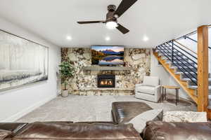 Carpeted living area with a fireplace, a ceiling fan, and recessed lighting