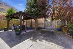 Fenced backyard featuring a patio area, a gazebo, and a mountain view