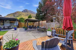 Deck with a patio, a gazebo, a fenced backyard, and outdoor dining area