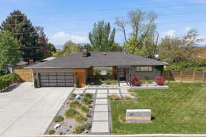 View of front of home featuring concrete driveway, an attached garage, a chimney, a porch, and brick siding