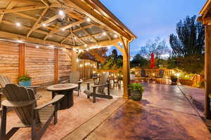 Patio terrace at dusk featuring a fire pit, a patio area, and ceiling fan