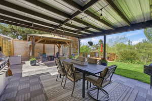 Wooden deck featuring a patio, a gazebo, outdoor dining space, a fenced backyard, and a grill
