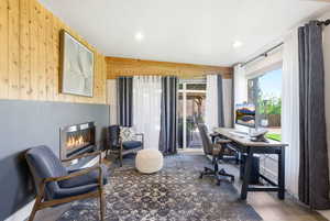 Home office with wood walls, a glass covered fireplace, recessed lighting, and wood finished floors