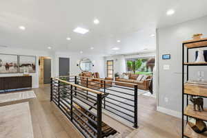 Living room with light wood-type flooring and recessed lighting