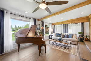 Living area featuring beam ceiling, a ceiling fan, light wood finished floors, plenty of natural light, and recessed lighting