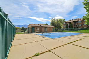 Community pool with a patio area and a mountain view