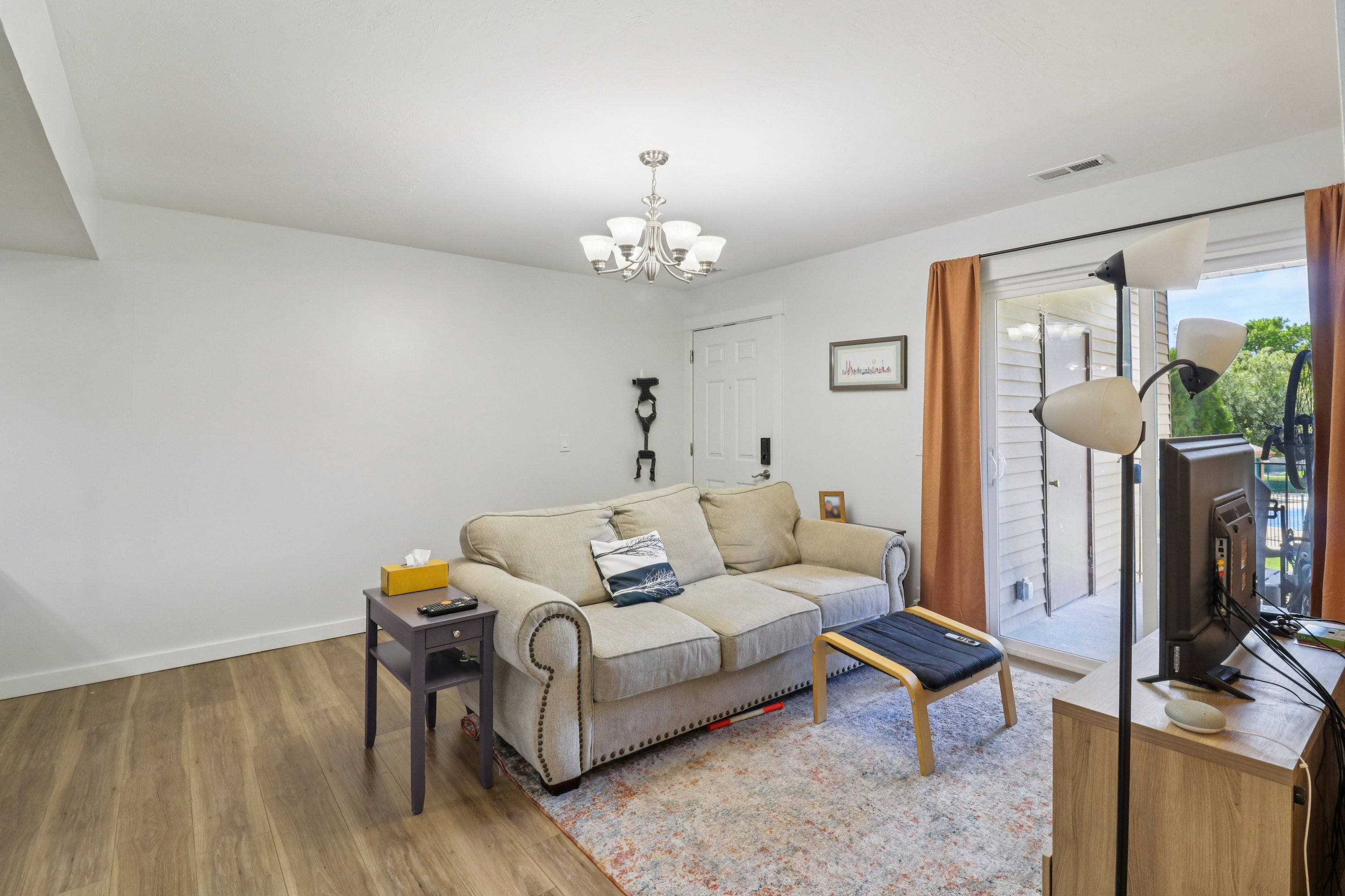 Living area featuring light wood-style flooring and suspended lighting