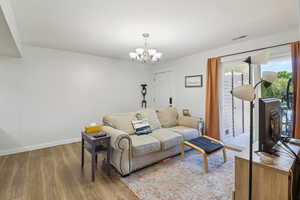 Living area featuring light wood-style flooring and suspended lighting