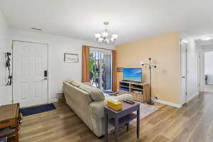 Living room with wood finished floors and a chandelier