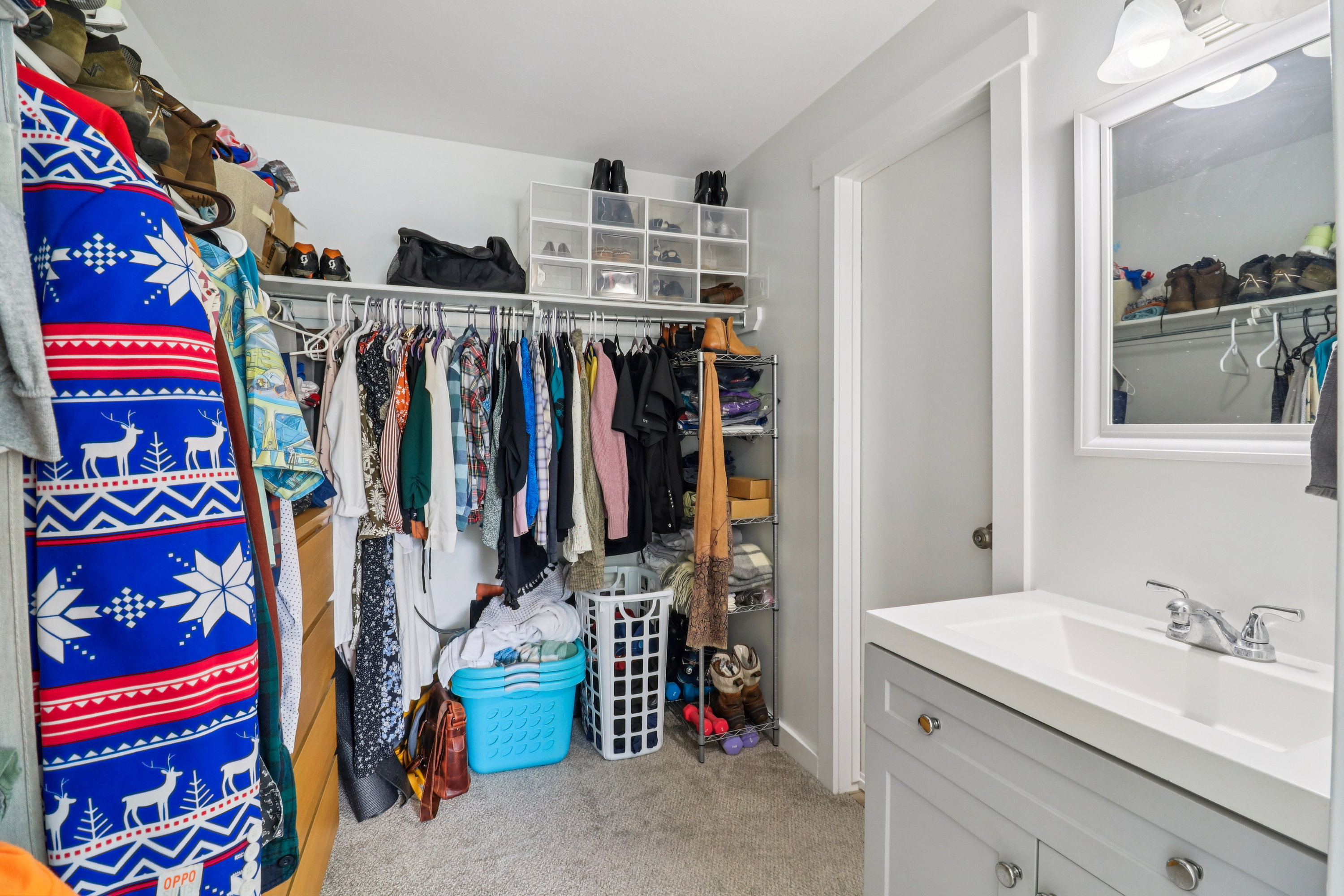 Walk in closet featuring light carpet and a sink
