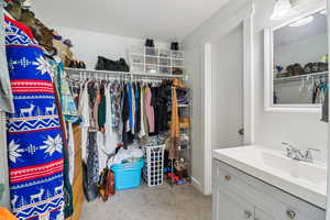 Walk in closet featuring light carpet and a sink