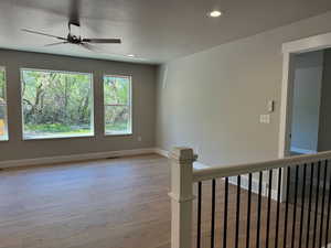 Spare room featuring light wood-type flooring, ceiling fan, recessed lighting, and a textured ceiling