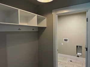 Mudroom with light tile patterned floors and baseboards