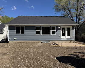 Rear view of property featuring a shingled roof
