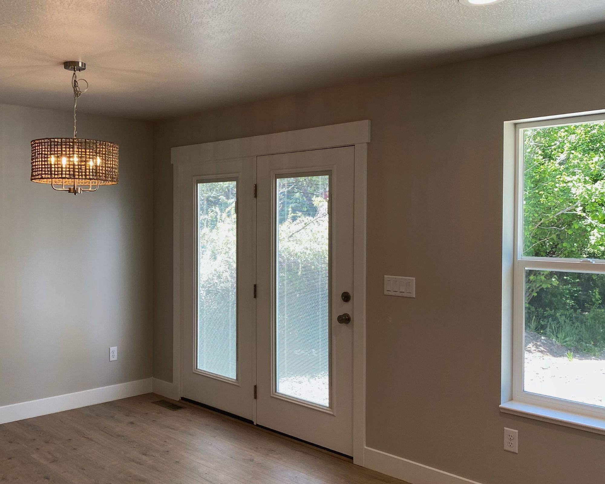 Doorway featuring wood finished floors, a textured ceiling, and suspended lighting