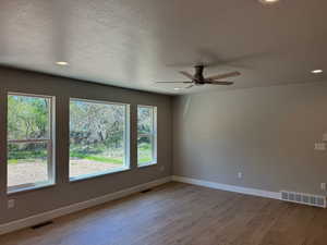 Spare room with light wood-type flooring, a textured ceiling, recessed lighting, and ceiling fan